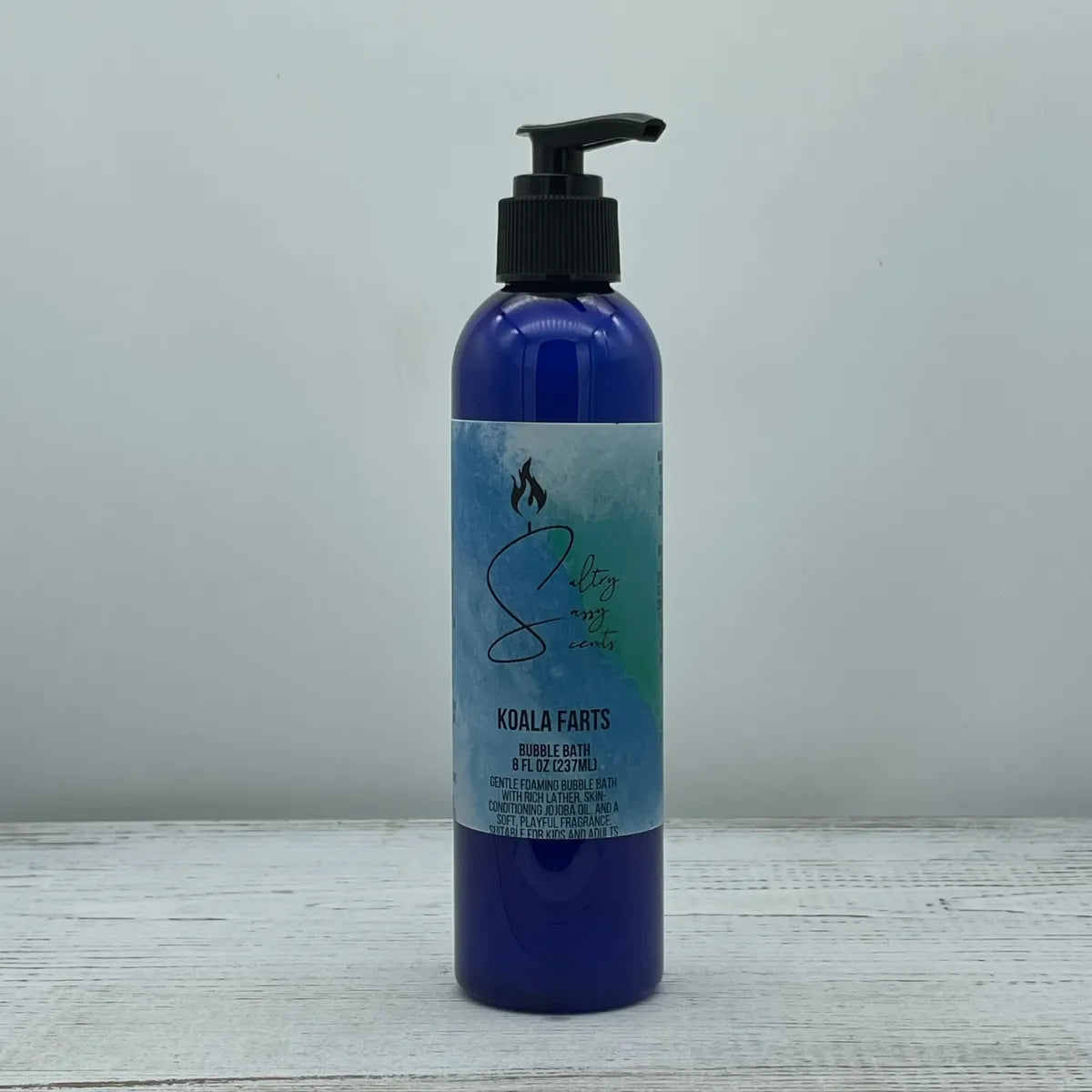 Front label view of a blue pump bottle containing Sultry Sassy Scents "Koala Farts" Bubble Bath, highlighting the text describing a gentle foaming formula with skin-conditioning jojoba oil.