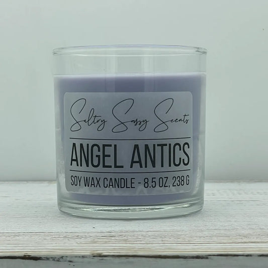 An 8.5-ounce jar of Sultry Sassy Scents "Angel Antics" soy wax candle featuring a soft purple wax color, displayed against a clean light background.