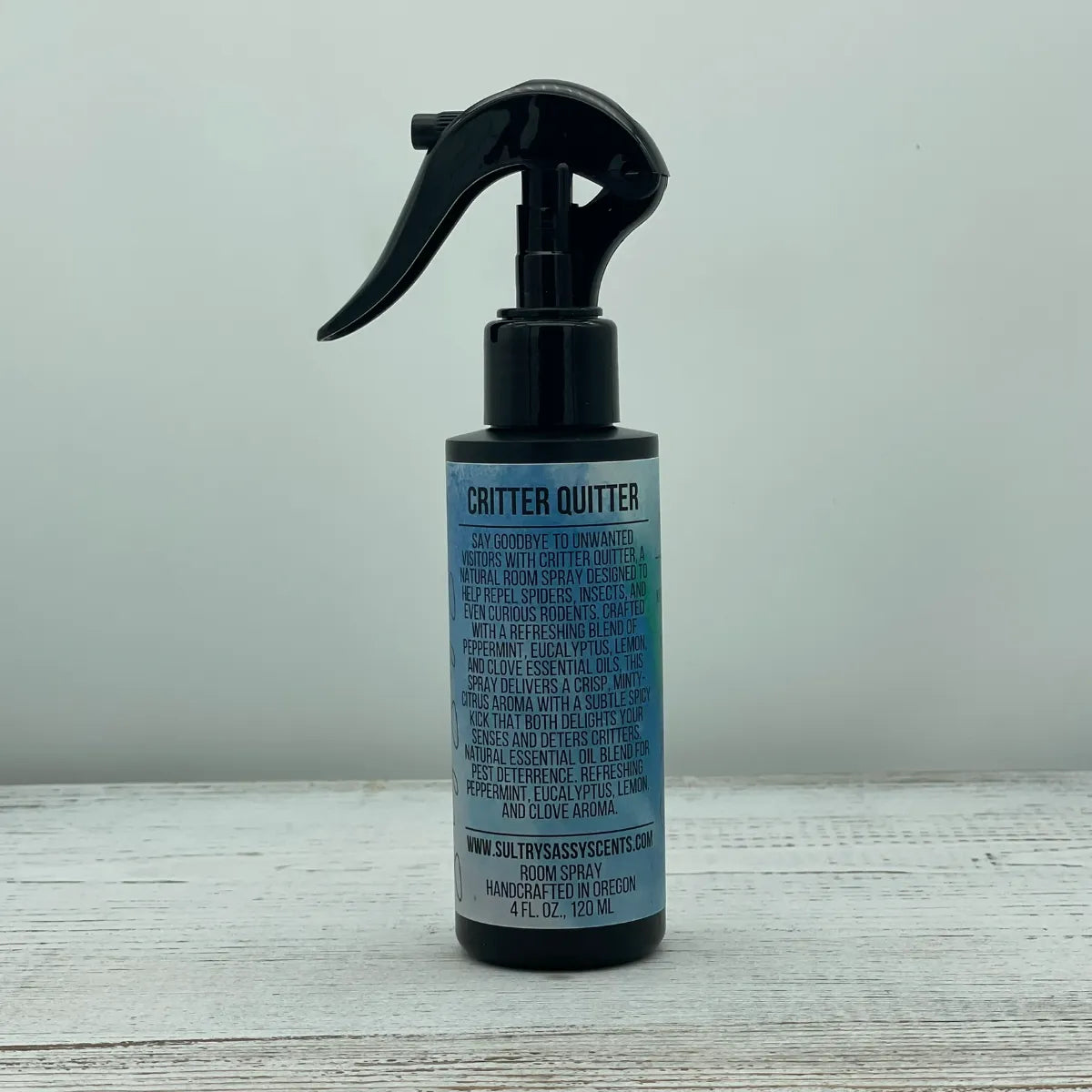 Front label of a black spray bottle for Sultry Sassy Scents "Critter Quitter" Natural Room Spray, displaying text detailing a refreshing pest deterrence blend of peppermint, eucalyptus, lemon, and clove essential oils.